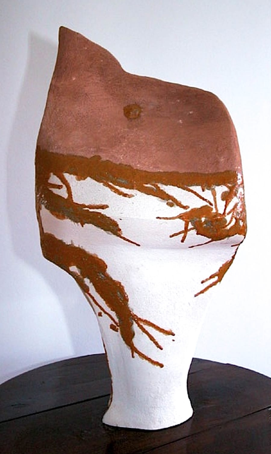 Esposizione oggetto di design in ceramica dal colore bianco e terra rossa