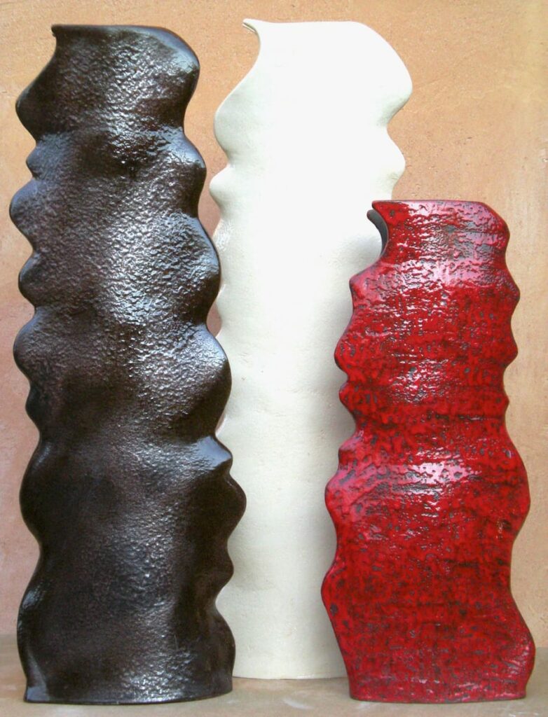 Esposizione di tre basi per lampade dal colore rosso, nero e bianco