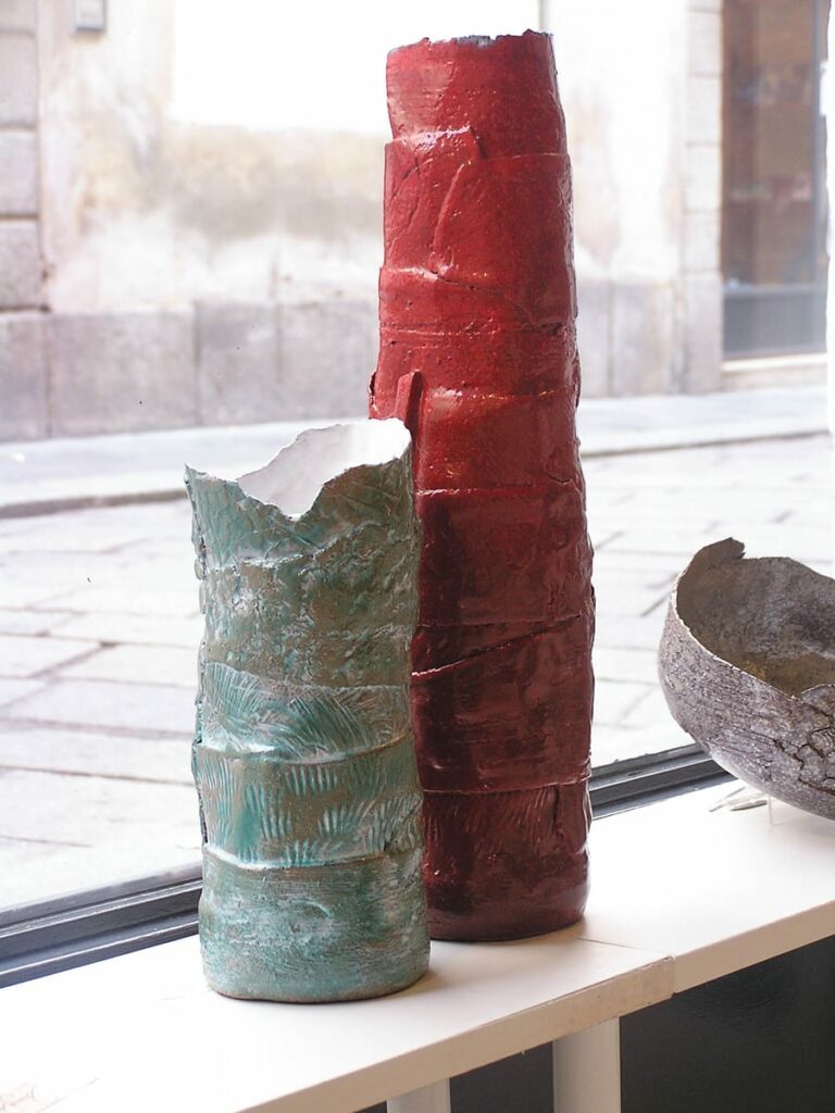 Esposizione di vasi in ceramica di diversi colori e dimensioni